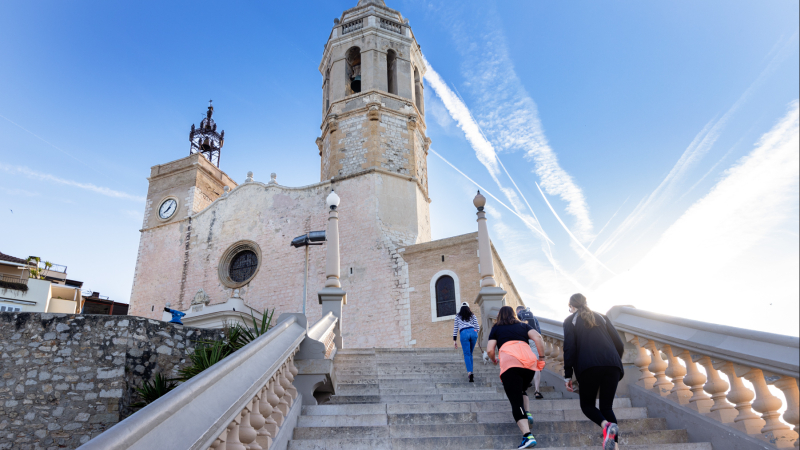 Persones pujant per les escales de l'Església Sant Bartomeu de Sitges. Autoria: Domènec Fernández