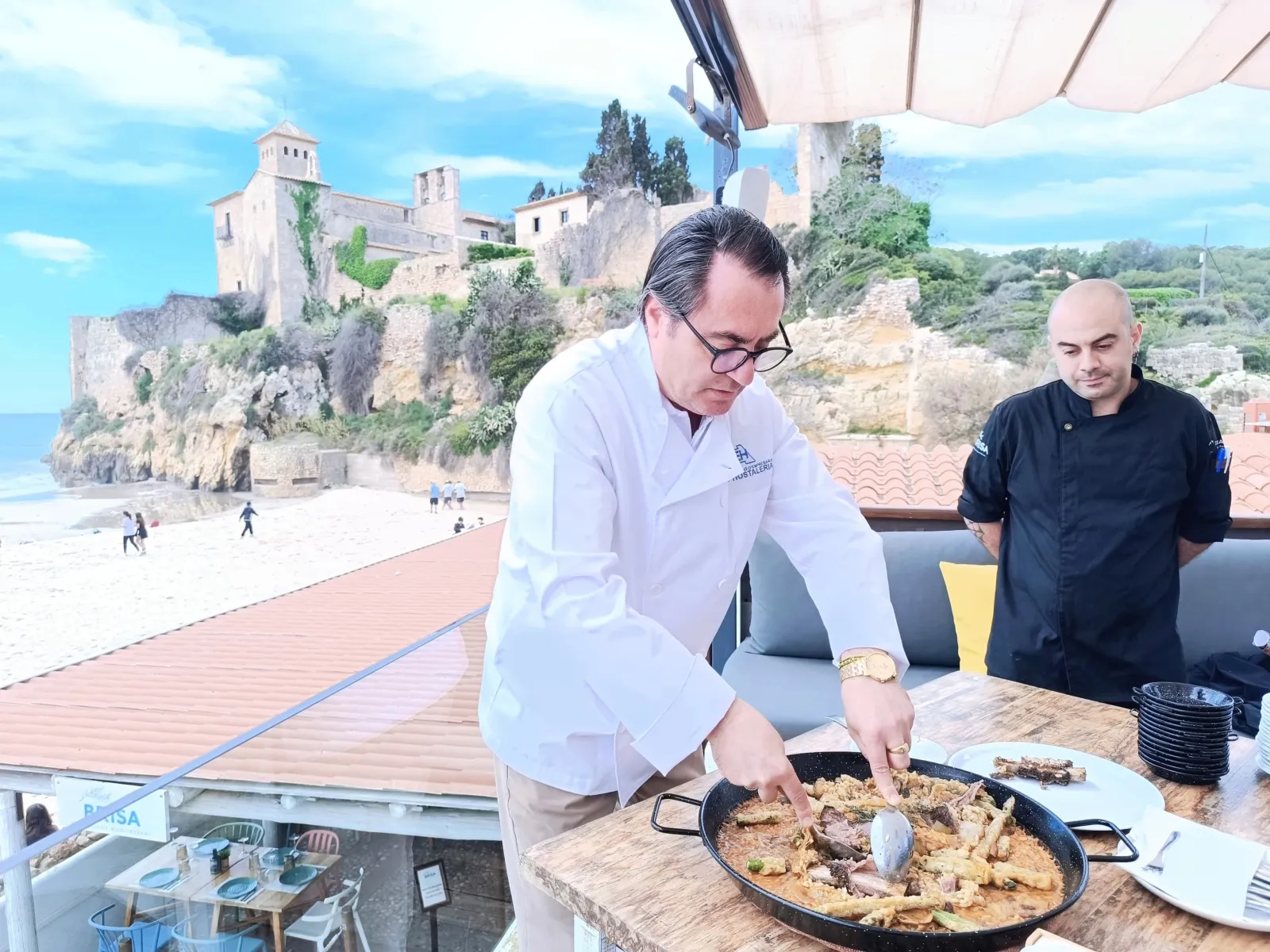 Xef cuinant un plat d’arròs mariner Xef cuinant un plat d’arròs mariner